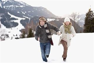 Couple Running Outdoors In Snow