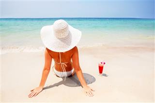 Woman Wearing Hat Relaxing On Beach