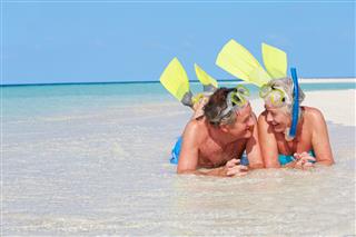 Couple At Beach With Snorkels And Flippers