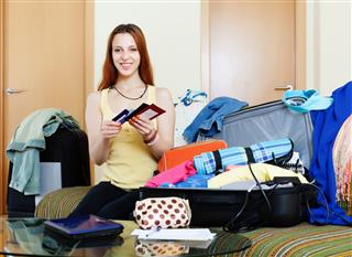 Woman Packing Documents Into Suitcases