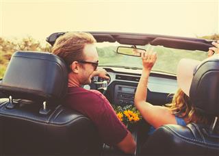 Happy Couple Driving In Convertible