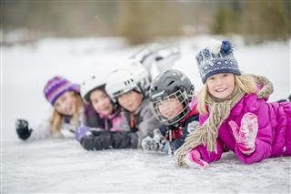 Group Of Children Lying On Frozen Lake