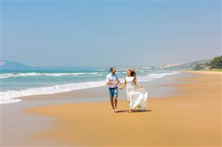 Bride And Groom Running On The Beach