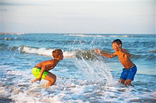 Two Boys Playing At The Beach