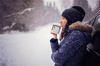 Girl Drinking Hot Tea In Snowy Forest