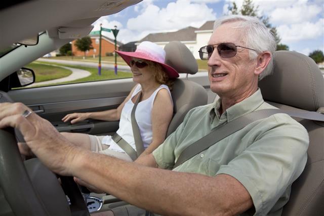 Senior Couple Driving Convertible Car