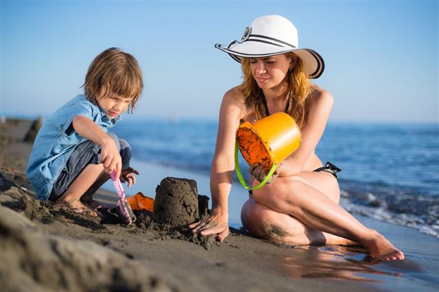 Mother Building Sandcastle With Her Son