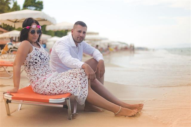 Man And Woman Sitting On The Beach