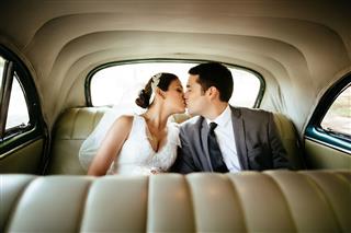 Hispanic Newlyweds Kissing In The Backseat