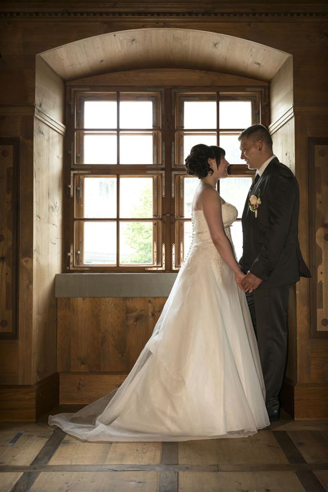 Happy Bridal Couple Standing At A Window