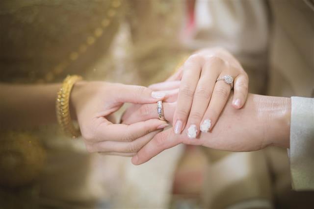 Thai groom wearing wedding ring